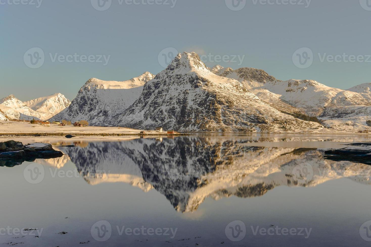 boos door bo met bergen reflecterend in de water. in de lofoten eilanden, Noorwegen in de winter. foto