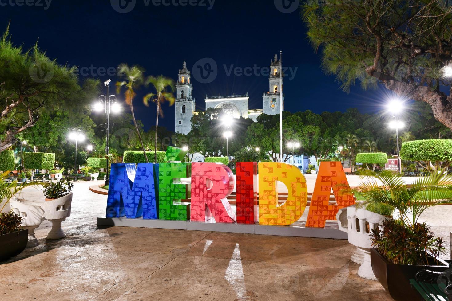 groot kleurrijk brieven vertegenwoordigen merida met een iconisch merida kathedraal Bij de achtergrond Bij nacht. foto