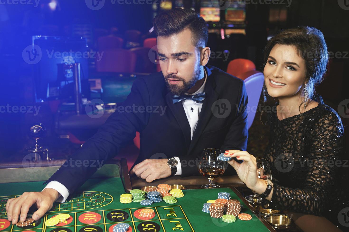 mooi en rijk paar spelen roulette in de casino foto