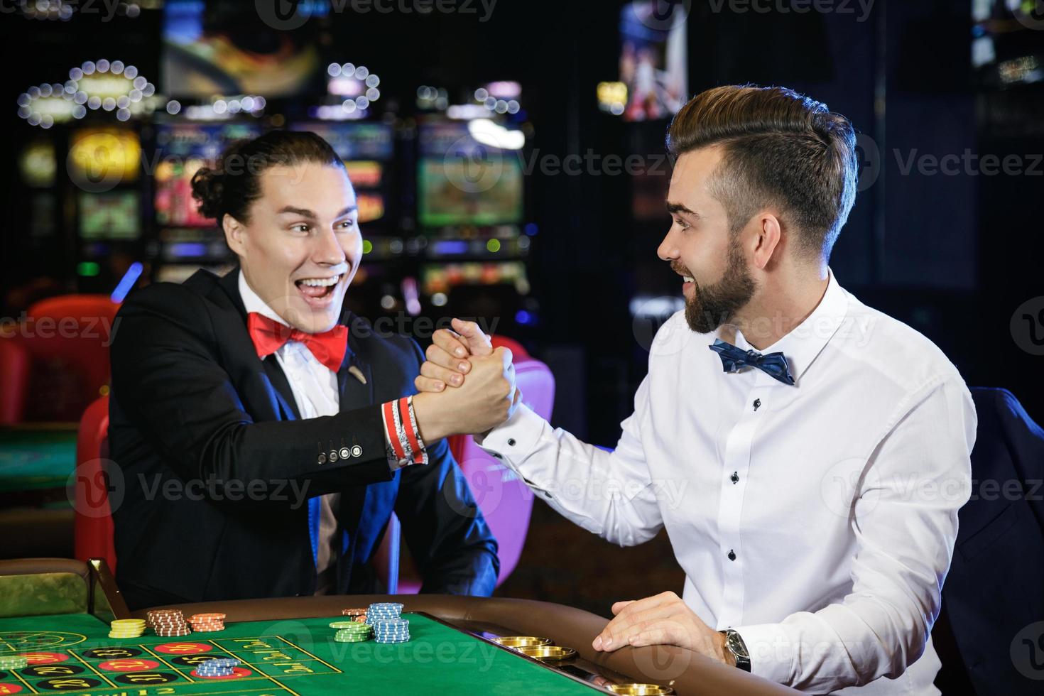 knap jongens spelen roulette in de casino foto