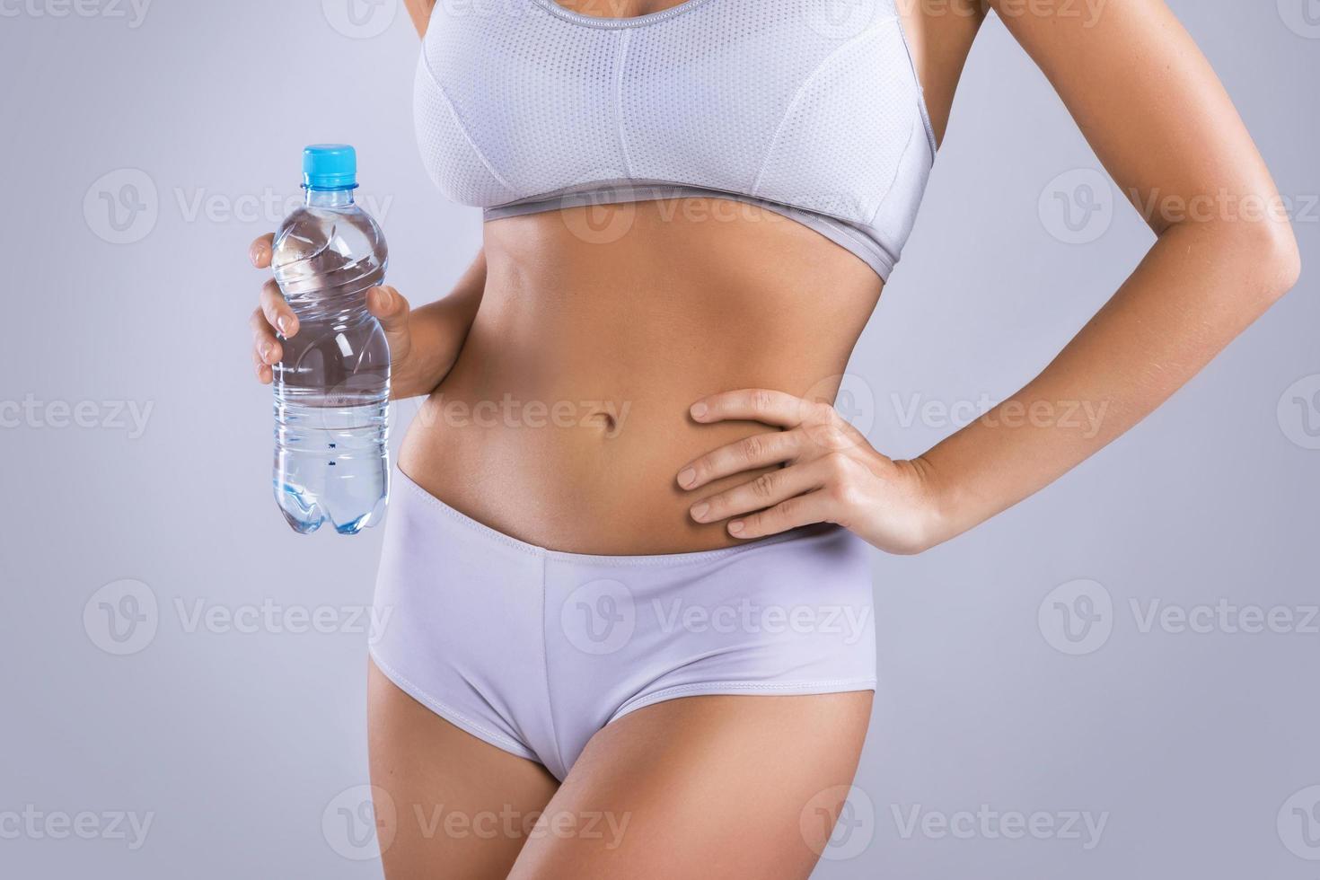 vrouw Holding fles van vers water in studio foto