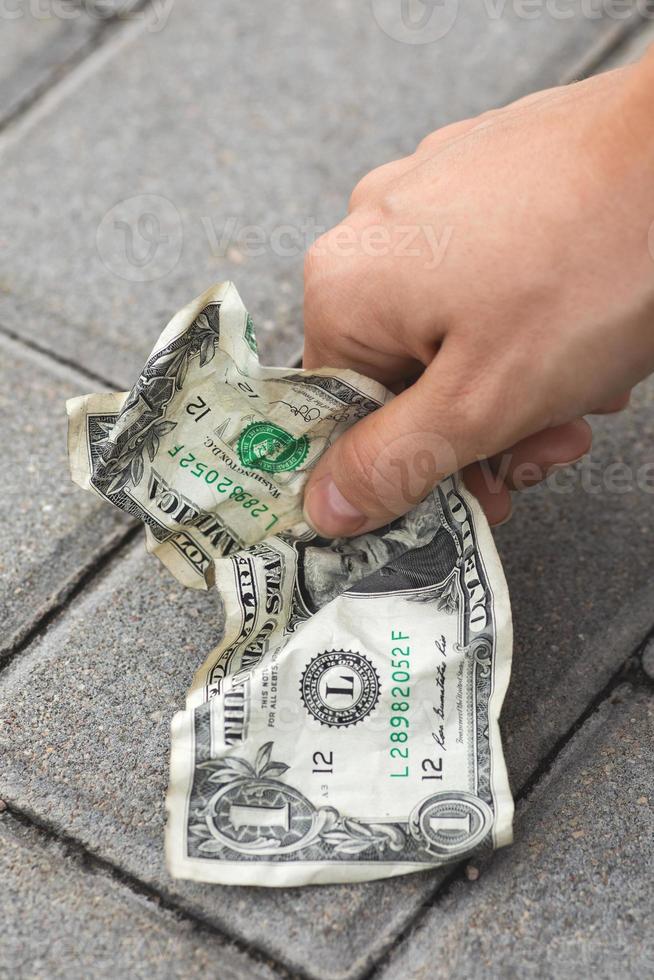arm vrouw plukken oud en verfrommeld een dollar Bill foto