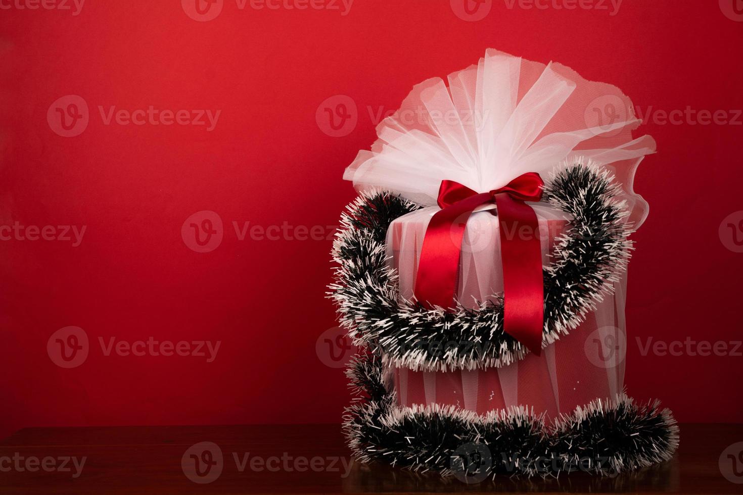 verpakt Kerstmis geschenk Aan rood achtergrond foto