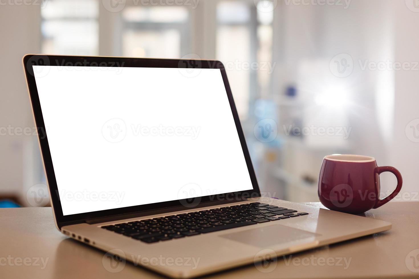 dichtbij omhoog laptop computer Aan top van kantoor tafel van een zakenman met leeg wit scherm, benadrukkend kopiëren ruimte. foto