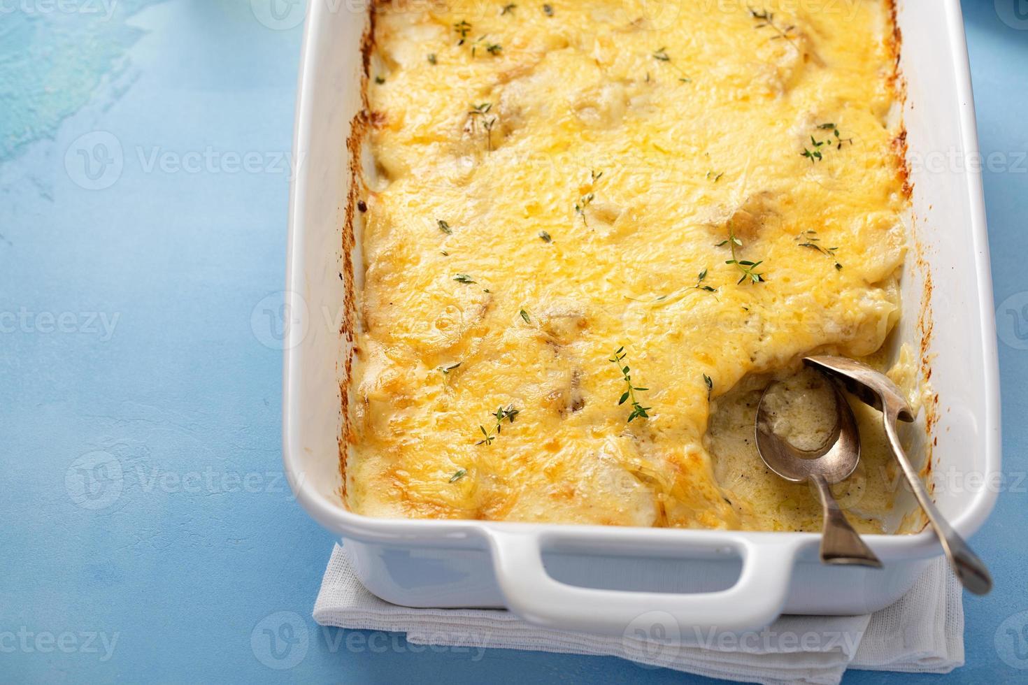 kaasachtig gebakken aardappelen in een bakken schotel met tijm foto