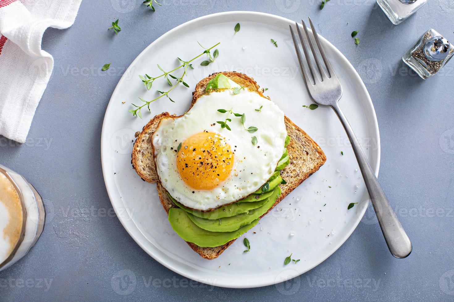 avocado geroosterd brood Aan een geroosterd meergranen brood met een gebakken ei foto