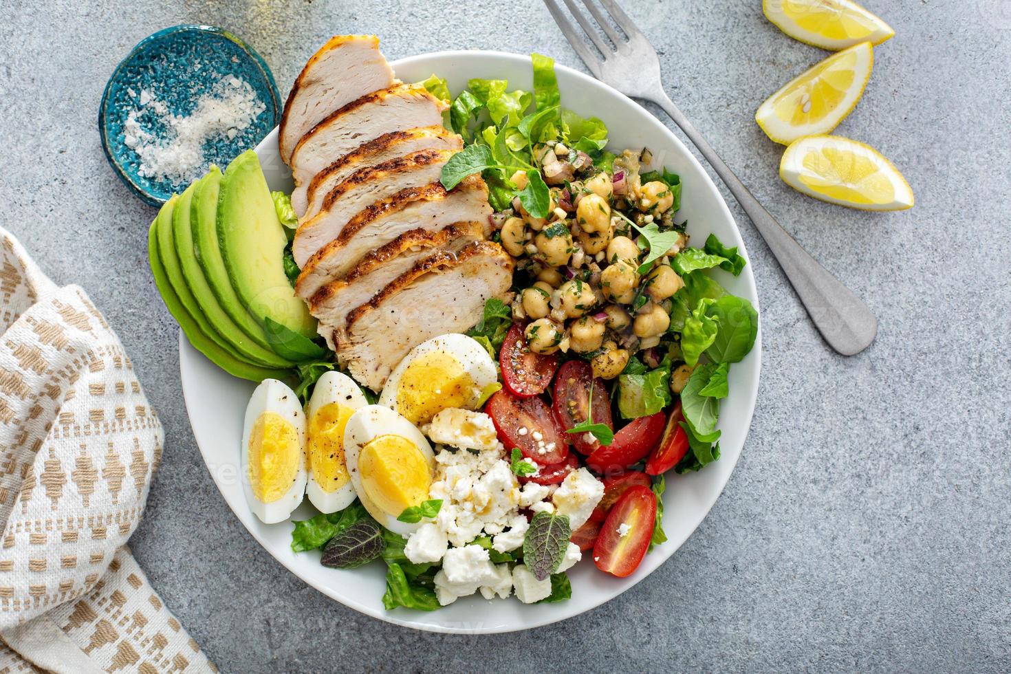 gezond salade lunch kom met kip, avocado en kikkererwten foto