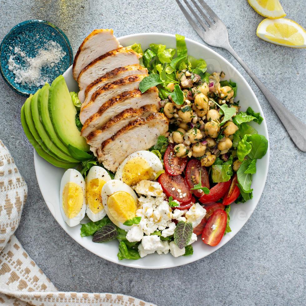 gezond salade lunch kom met kip, avocado en kikkererwten foto