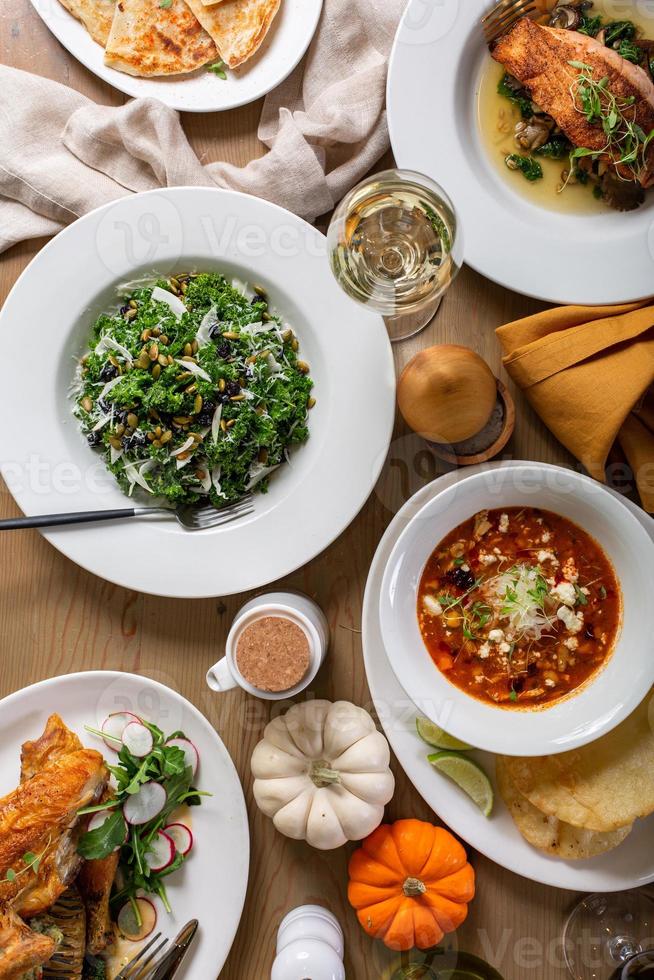 vallen avondeten tafel met soep, salade en hoofd gerechten foto