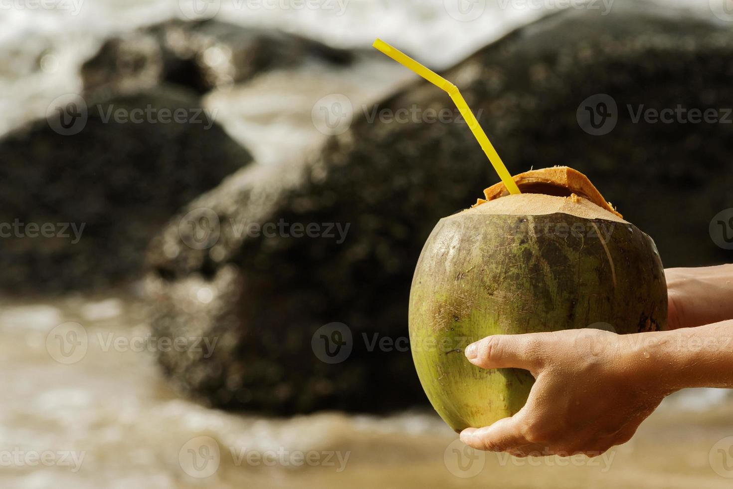 vrouw met een kokosnoot drinken Aan de tropisch strand foto