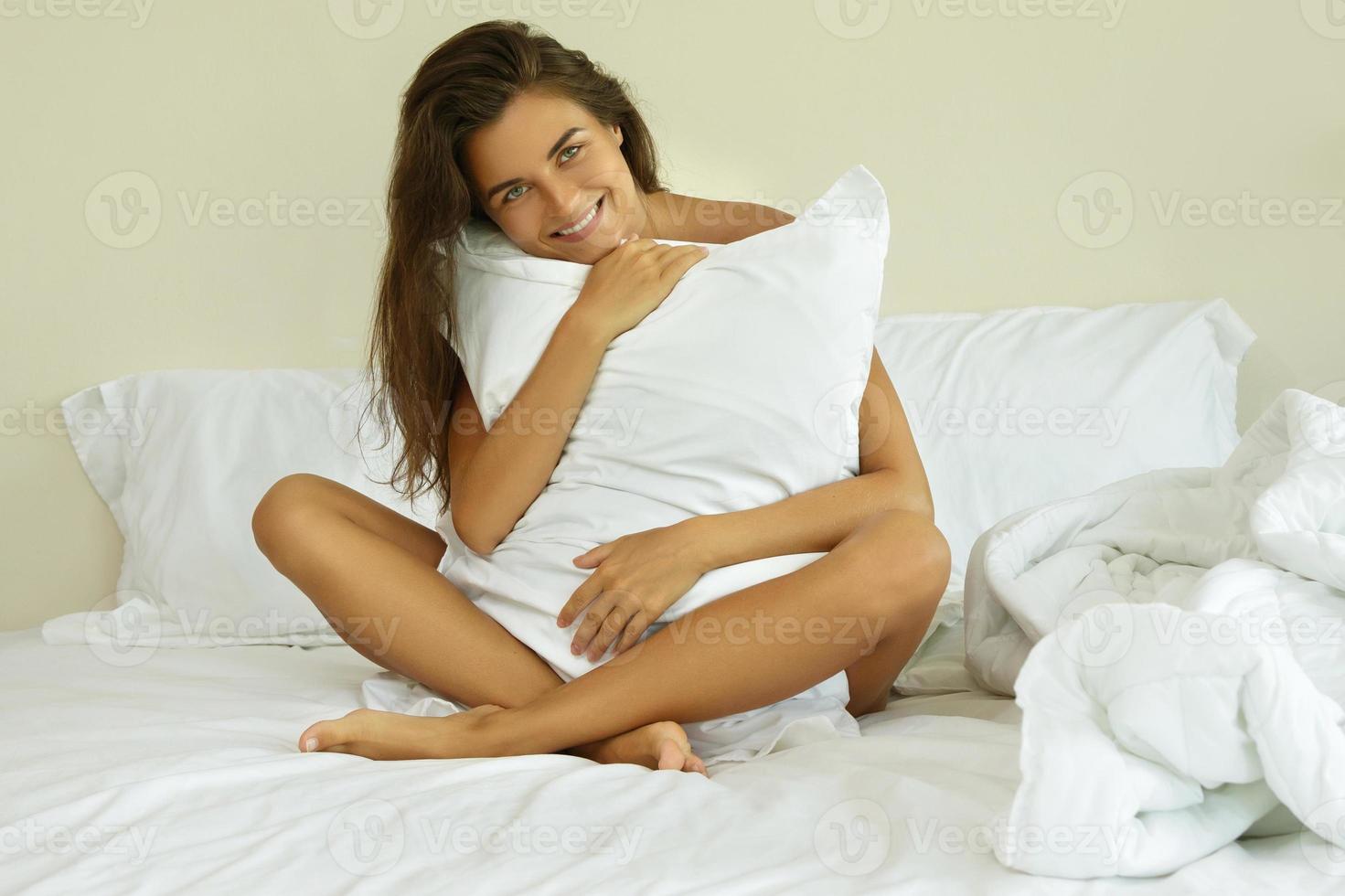 mooi vrouw is zittend Aan de bed foto