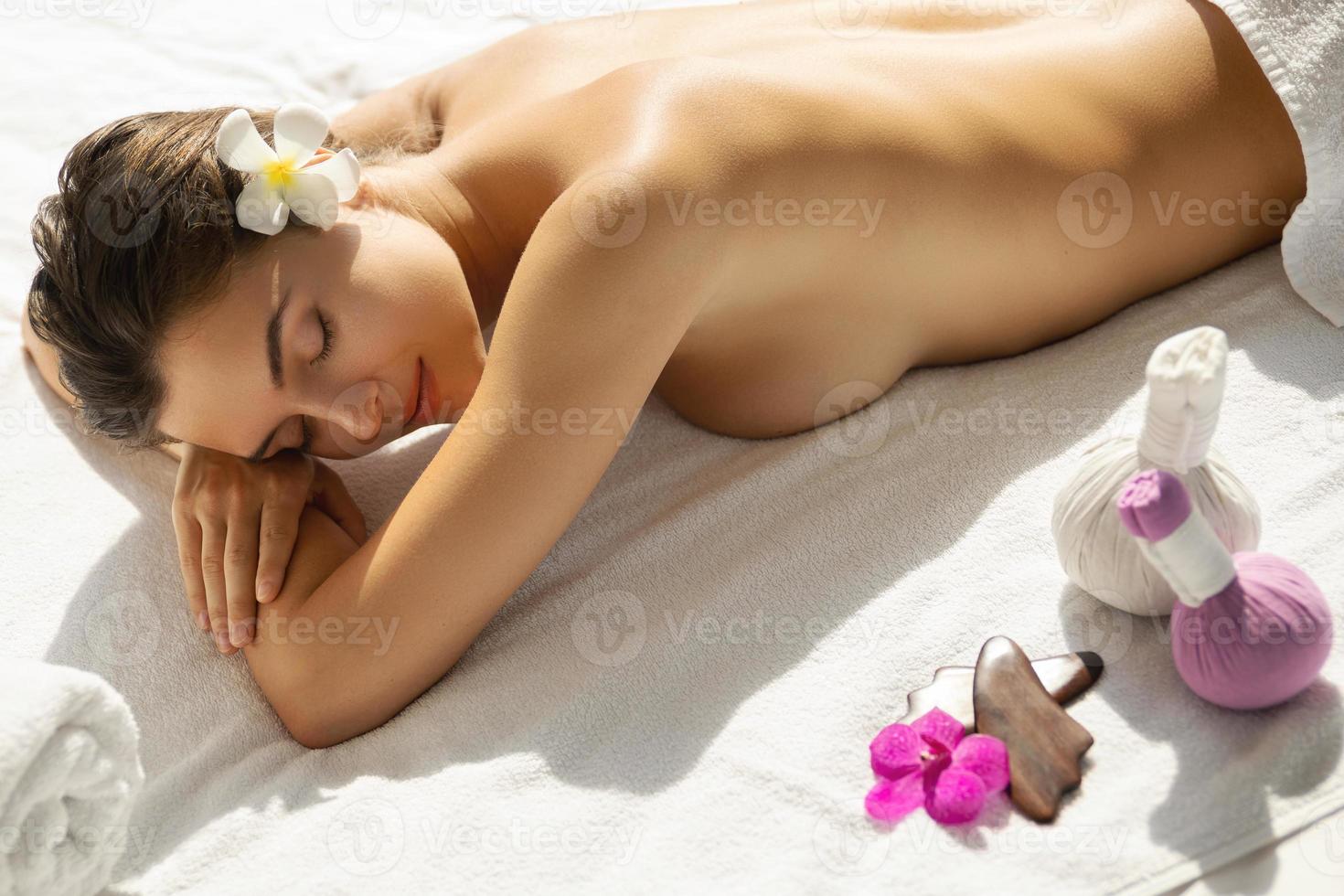 mooi vrouw is ontspannende gedurende sessie van Aziatisch massage foto