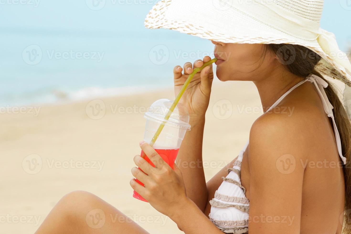 vrouw in strand hoed met een cocktail foto