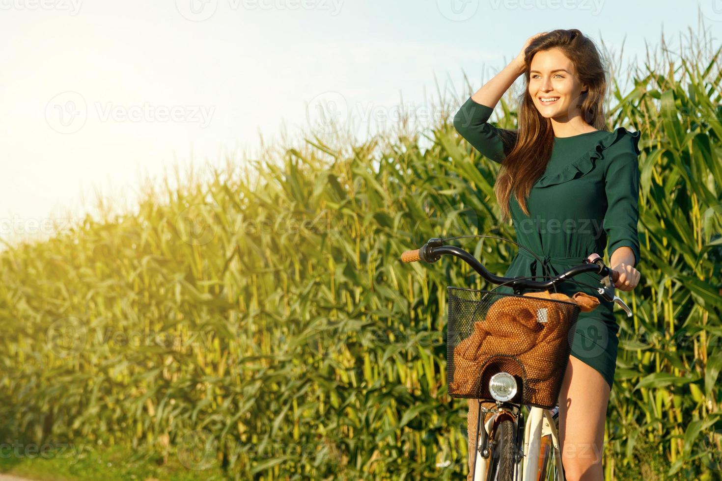 vrouw is wielersport door de land weg in de korenveld foto