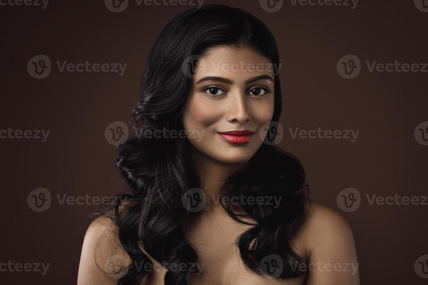 Indisch vrouw met mooi bedenken en kapsel Aan bruin achtergrond foto