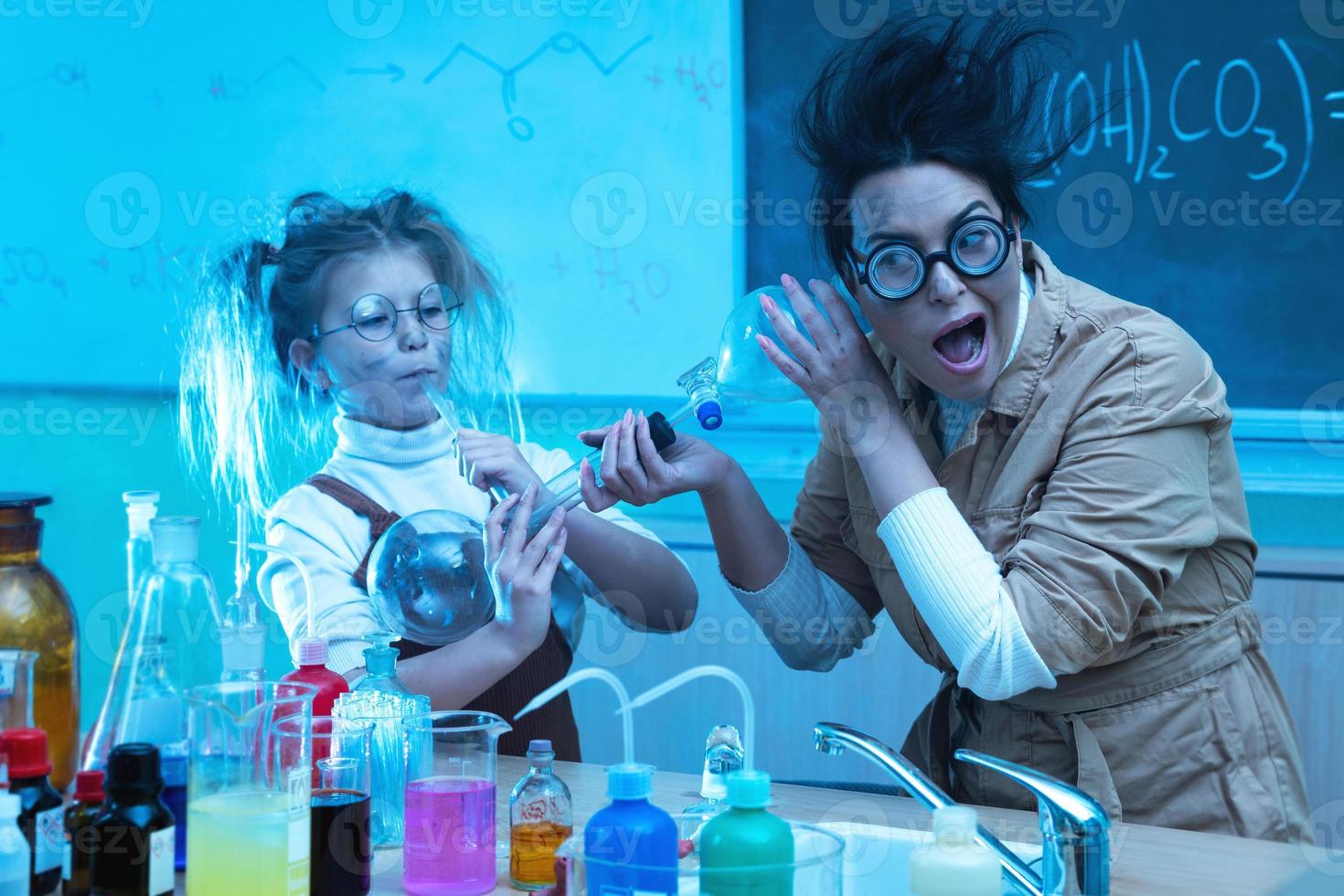 leraar en weinig meisje gedurende chemie les menging Chemicaliën in een laboratorium foto