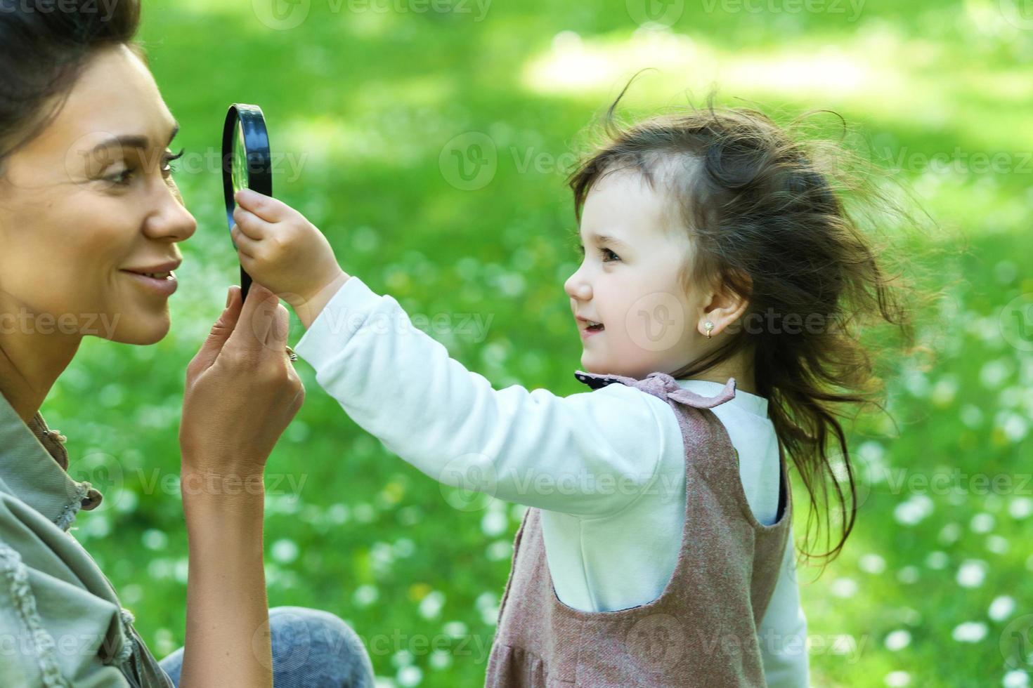 moeder en dochter spelen met een vergrootglas foto