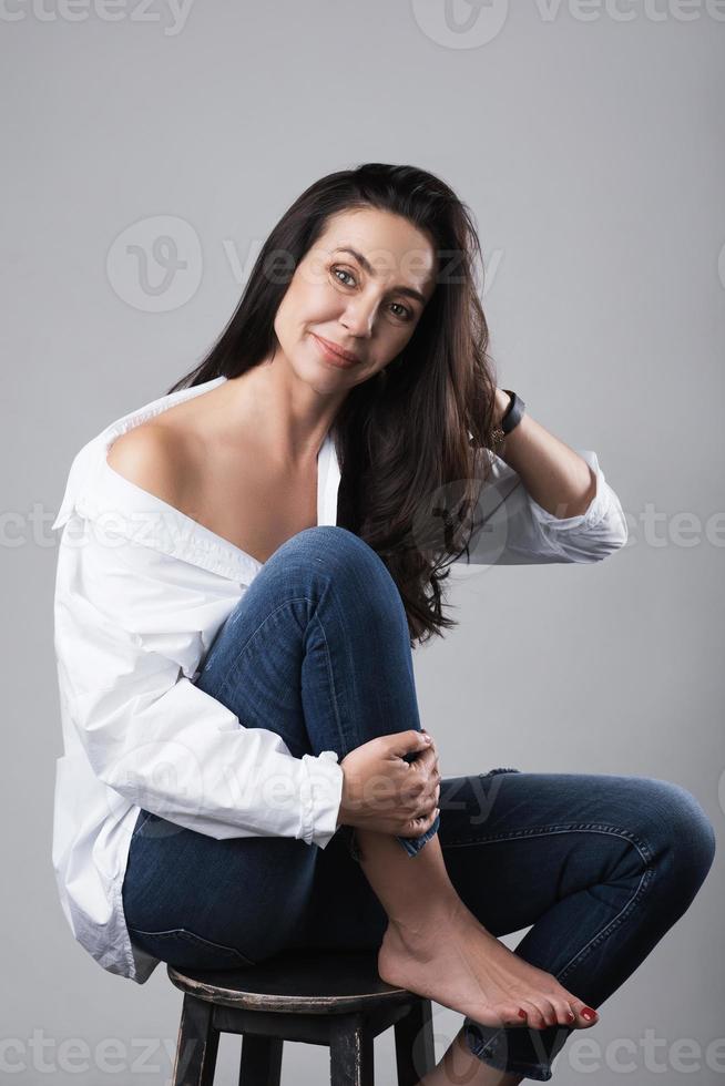 mooi midden- oud mode model- vervelend wit overhemd en jeans in een foto studio