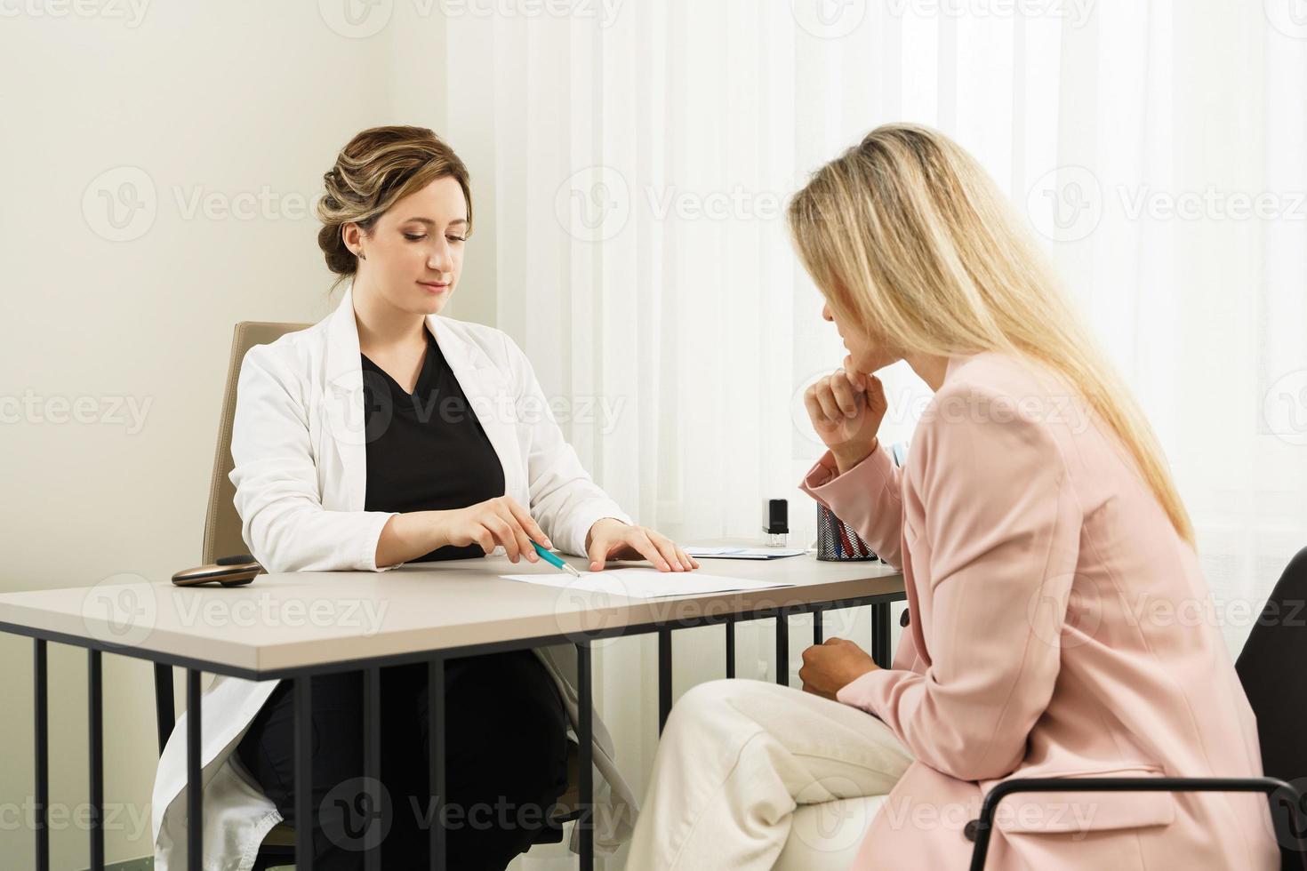 vrouw dokter en geduldig gedurende overleg foto