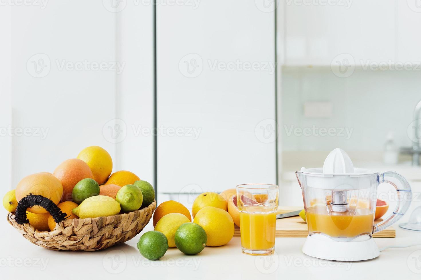 glas van oranje sap, citrus sapcentrifuge en divers citrus fruit Aan keuken tafel foto