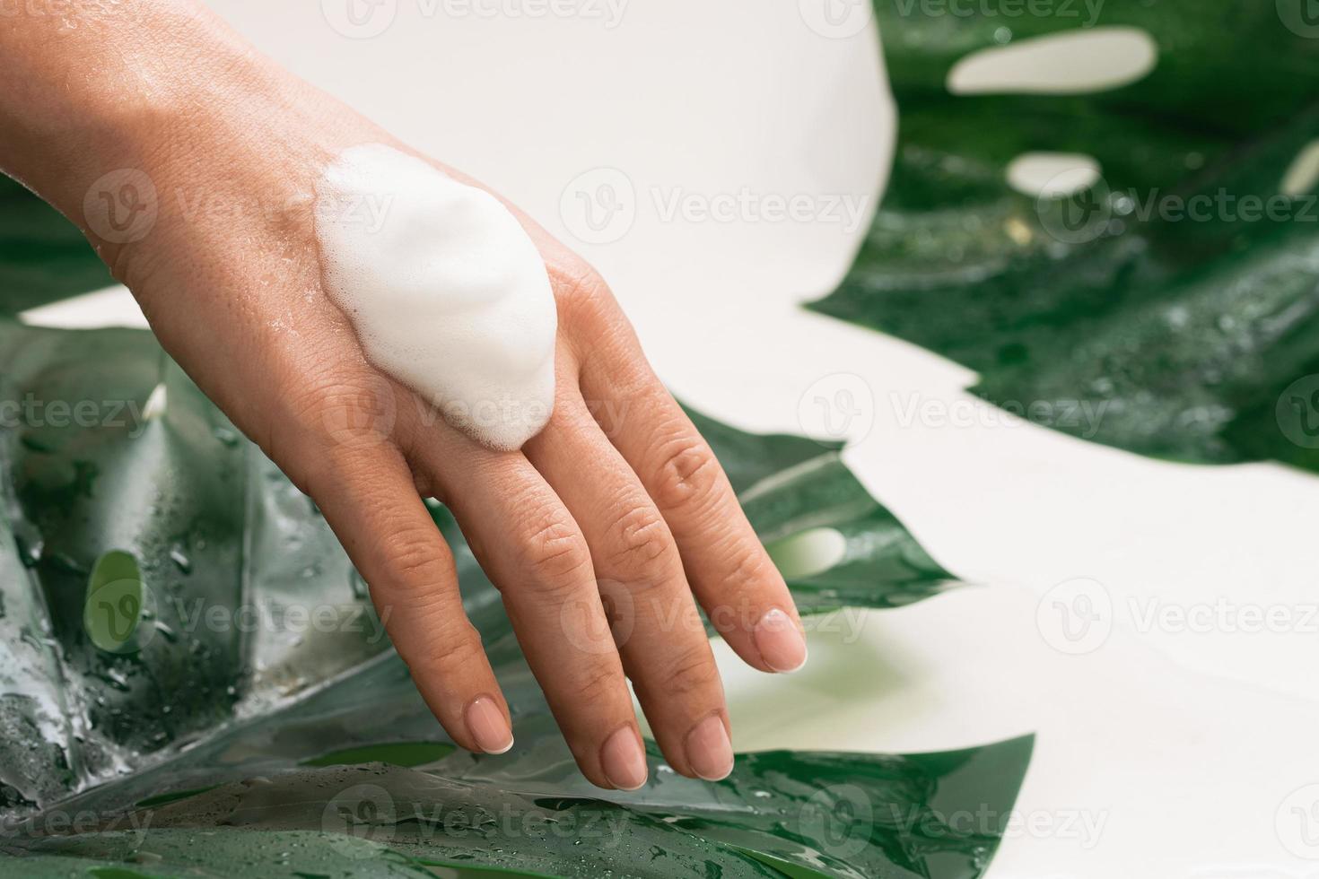 detailopname van vrouw hand- met een reiniging schuim foto