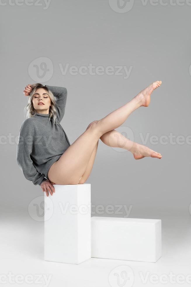 jong en sexy vrouw met blond haar- vervelend coltrui jumper is poseren in studio foto