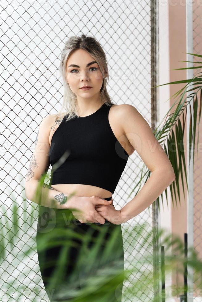 jong sportief blond vrouw vervelend zwart sportkleding foto