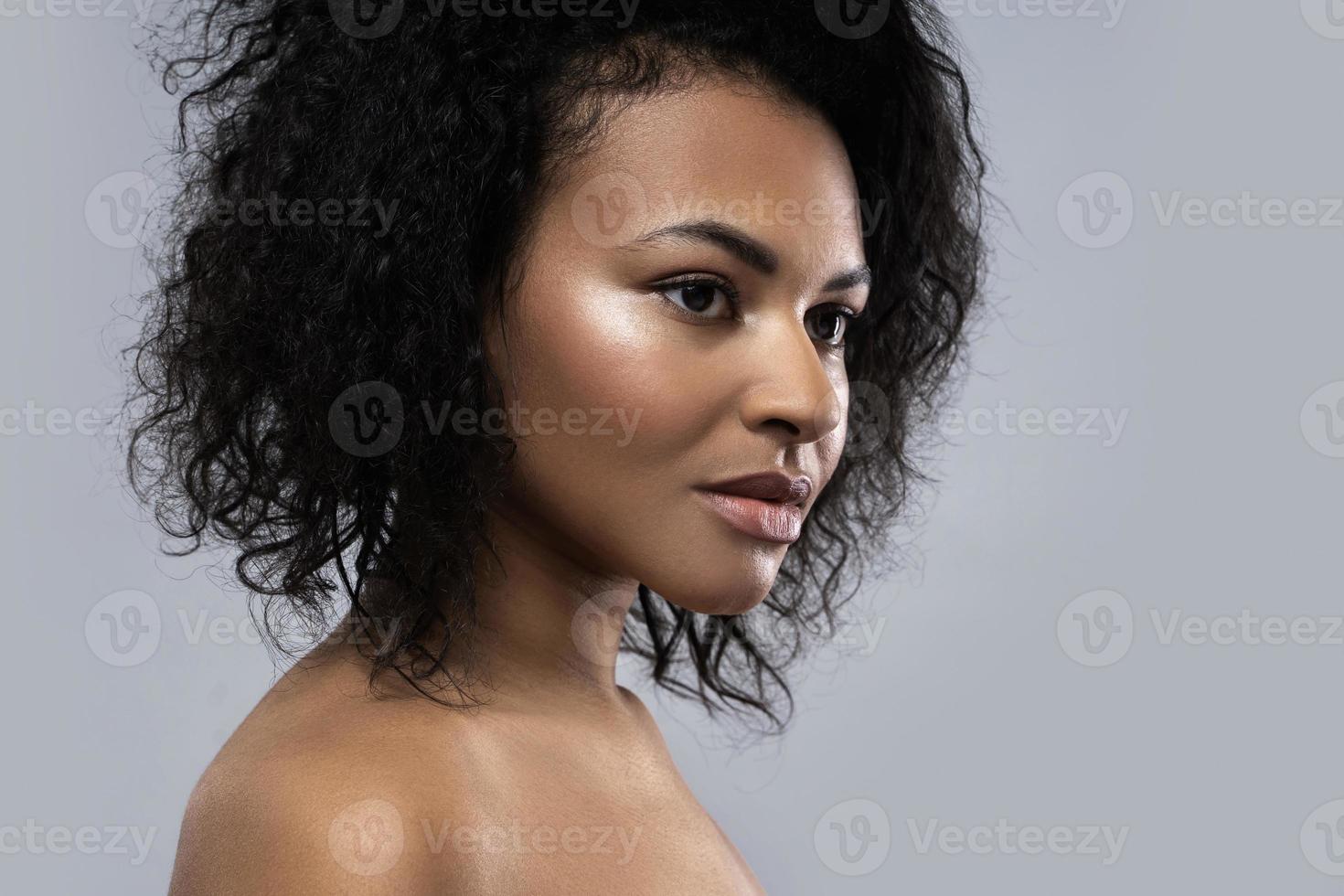 mooi zwart vrouw met glad huid tegen grijs achtergrond foto
