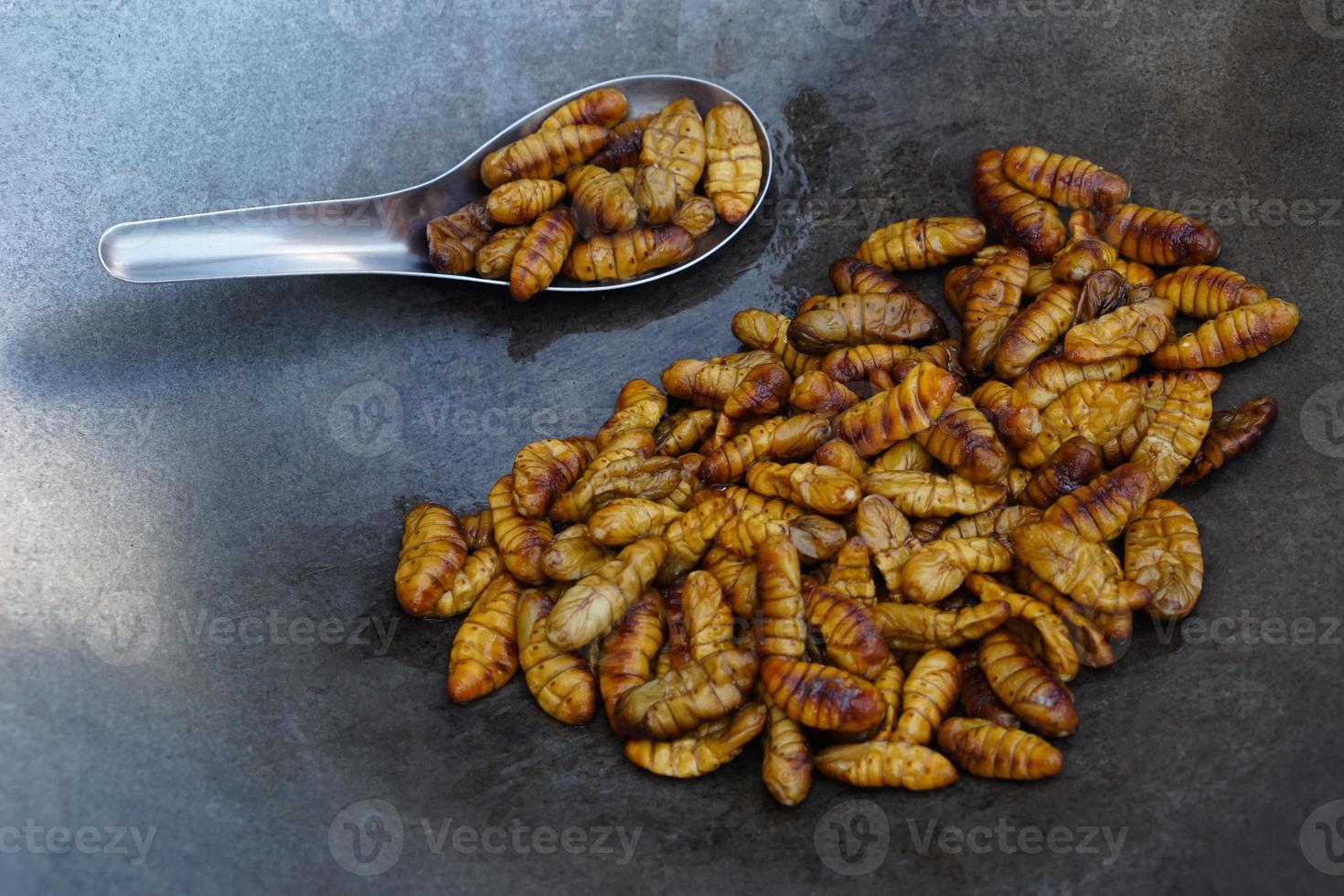 detailopname gebakken zijde wormen Aan pan. concept, raar voedsel. insecten aan het eten. hoog eiwit. traditioneel Thais straat voedsel in Thailand. eetbaar wormen. foto