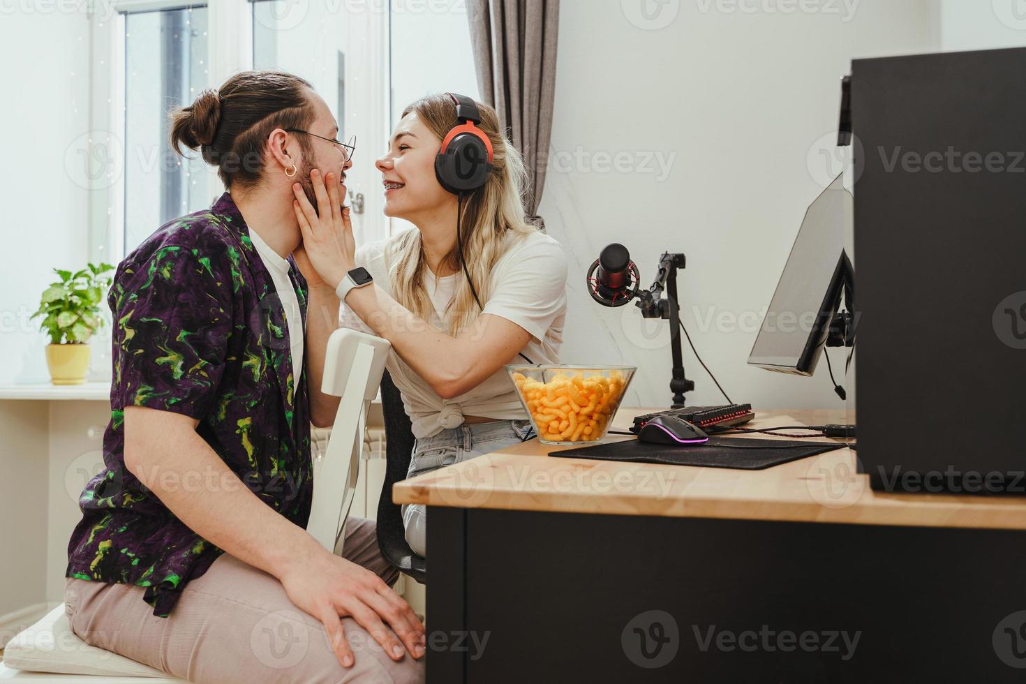 jong paar ontspannende en tonen liefde terwijl spelen video spellen Aan een persoonlijk computer foto