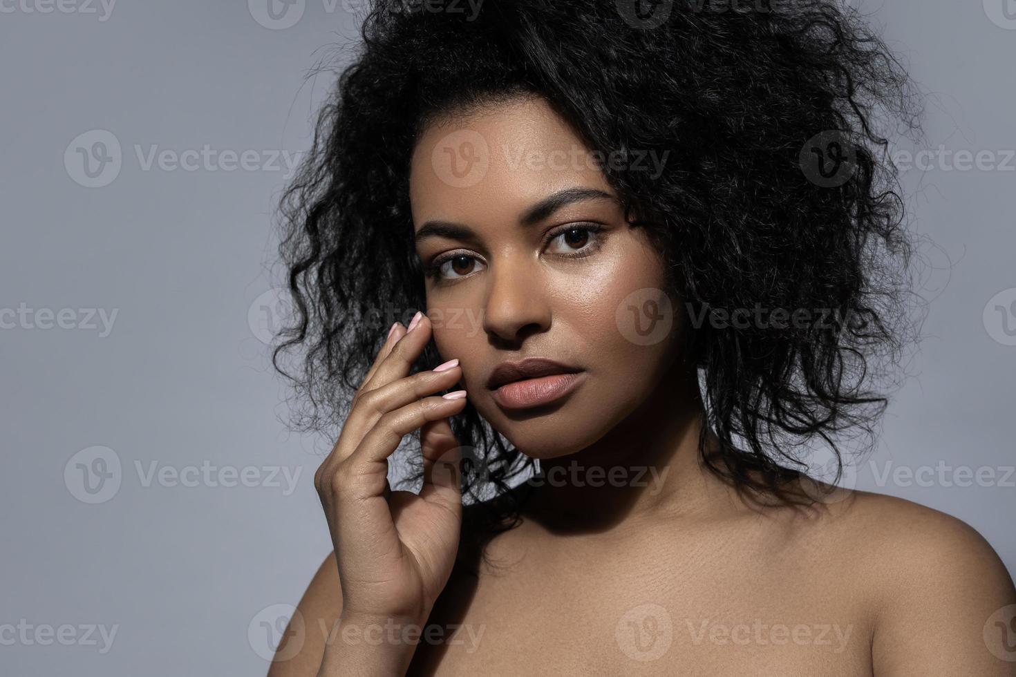 mooi zwart vrouw met glad huid tegen grijs achtergrond foto