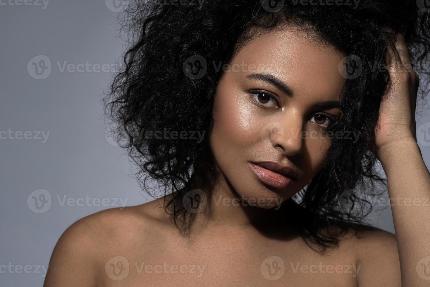 mooi zwart vrouw met glad huid tegen grijs achtergrond foto