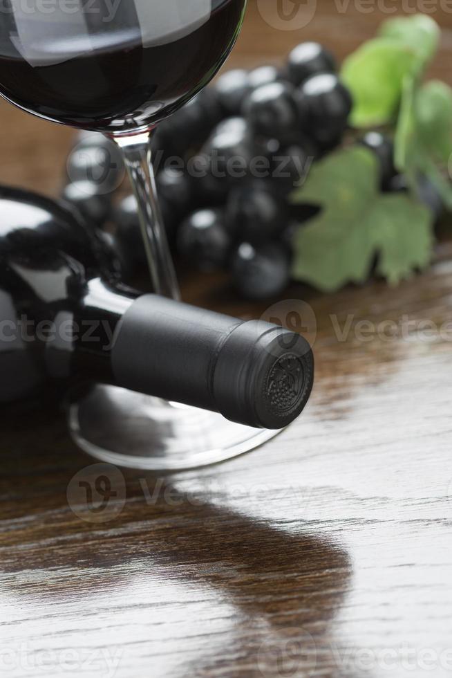 abstract wijn fles, glas en druiven Aan reflecterende hout oppervlakte foto