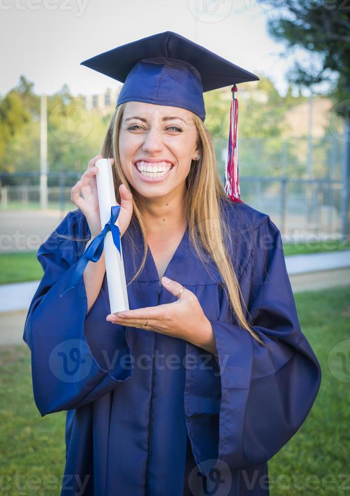 expressief jong vrouw Holding diploma in pet en japon foto