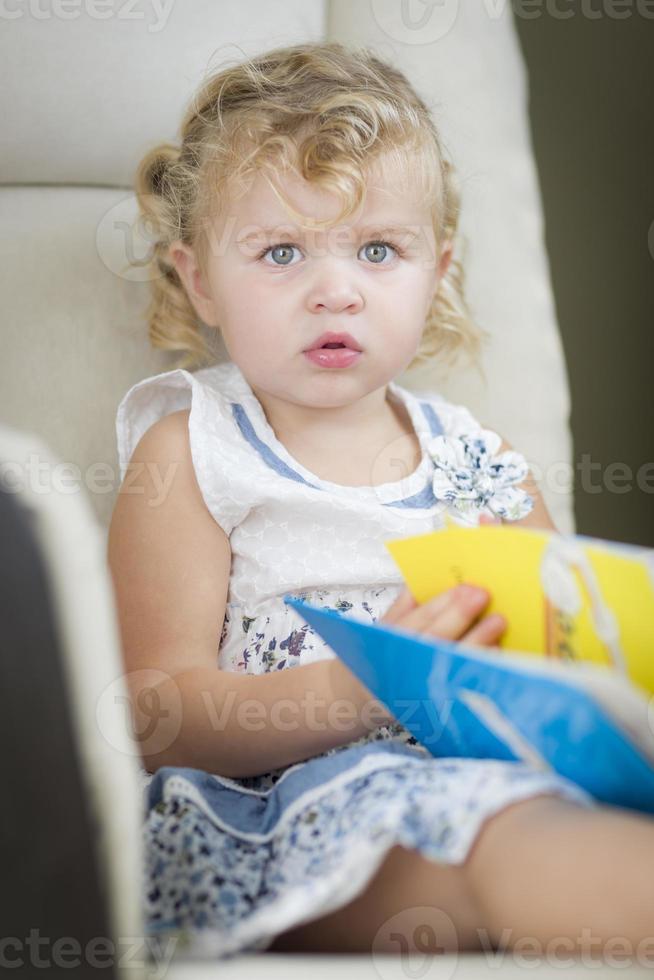 blond haren blauw ogen weinig meisje lezing haar boek foto