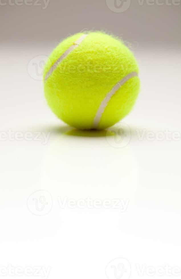 single tennis bal Aan gradatie met licht reflectie foto