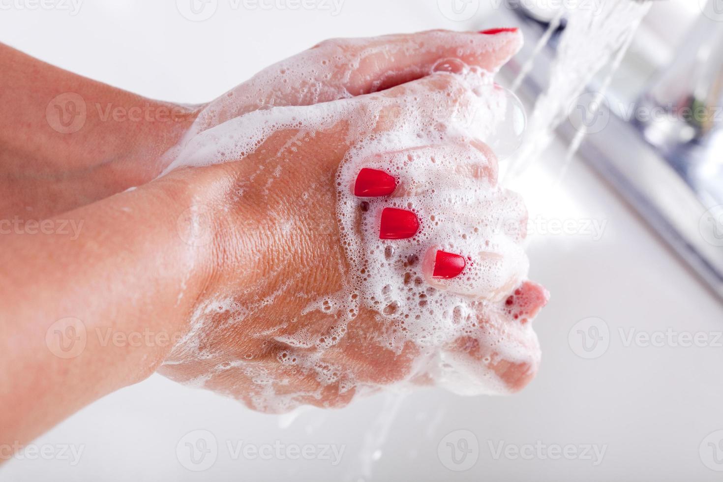 vrouw grondig het wassen handen in de wastafel bassin. foto