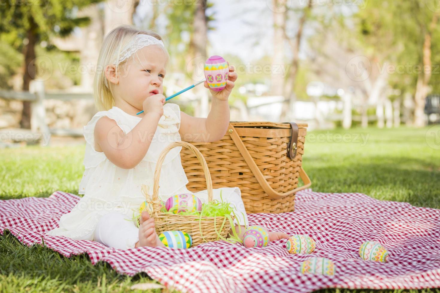 schattig baby meisje kleur Pasen eieren Aan picknick deken foto