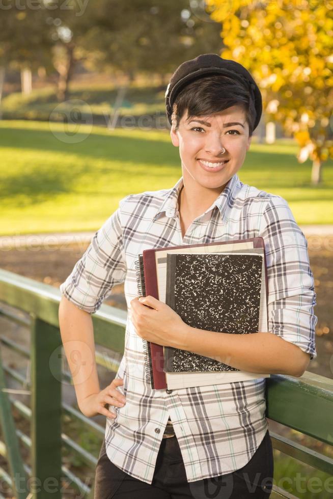 portret van een mooi gemengd ras vrouw leerling Holding boeken foto