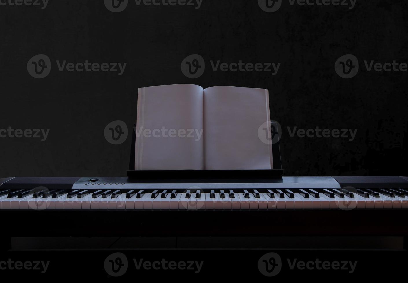 elektrisch piano met leeg vel muziek- Aan zwart achtergrond, piano toetsenbord Aan donker achtergrond concept kunst, voorkant visie foto