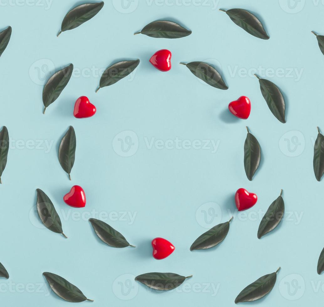 creatief cirkel arrangeurs met rood harten en groen bladeren Aan een blauw achtergrond. valentijnsdag dag en voorjaar concept met kopiëren ruimte. vlak leggen. minimaal natuur. foto