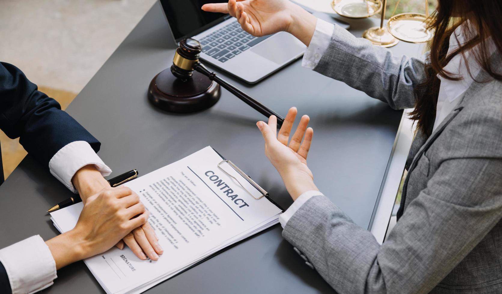 mannelijke advocaat die met contractdocumenten en houten hamer op tafel in rechtszaal werkt. justitie en recht, advocaat, rechter, concept. foto