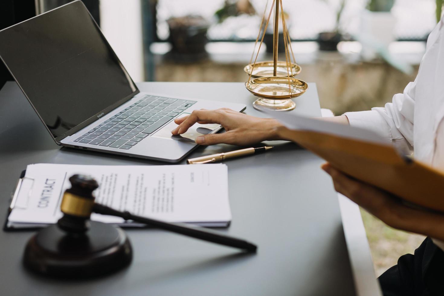 mannelijke advocaat die met contractdocumenten en houten hamer op tafel in rechtszaal werkt. justitie en recht, advocaat, rechter, concept. foto