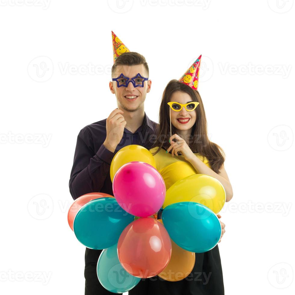 homo jong vent met een meisje, Holding in de buurt de oog papier bril en veel van gekleurde heet lucht ballon foto