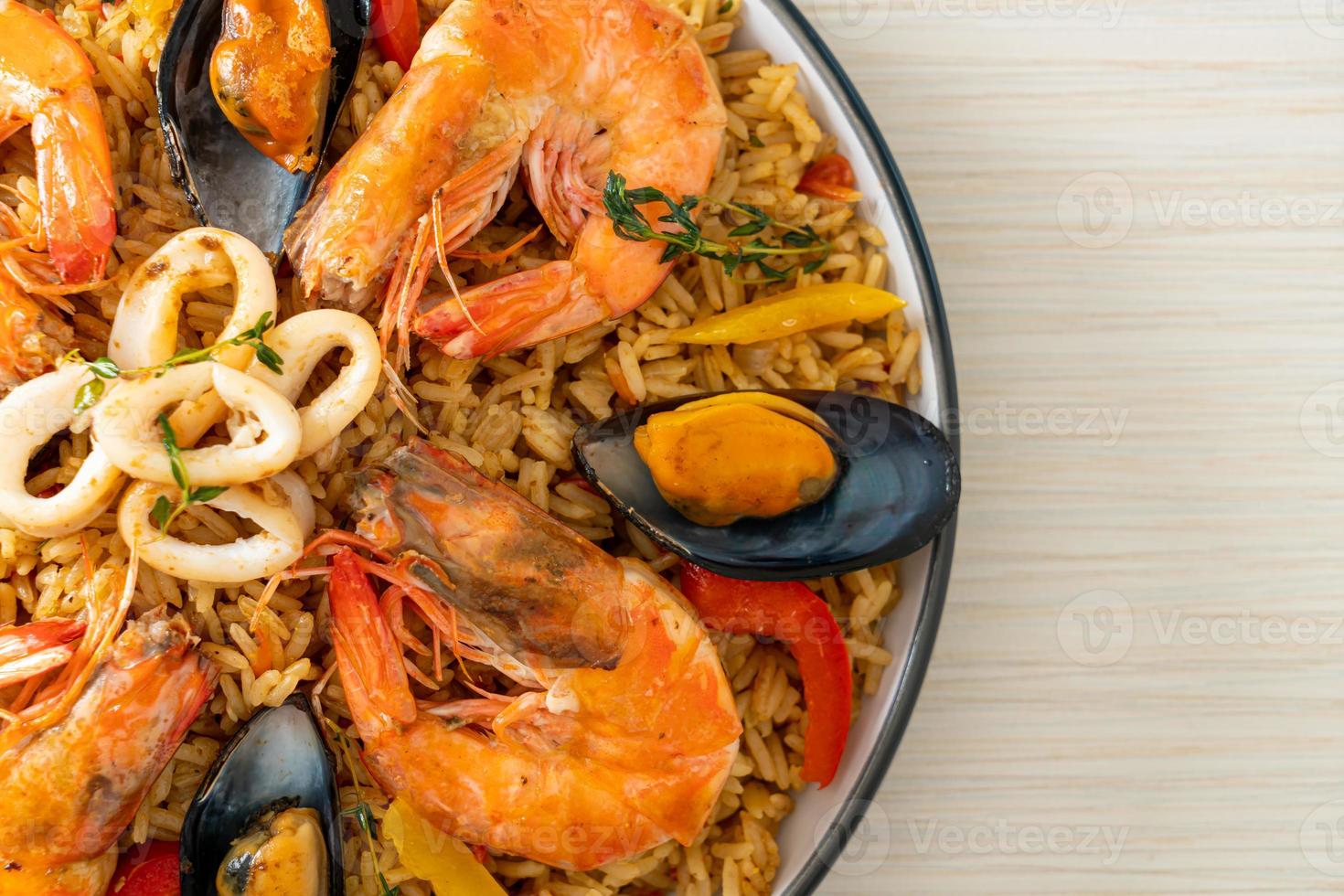 zeevruchtenpaella met garnalen, kokkels, mosselen op saffraanrijst foto