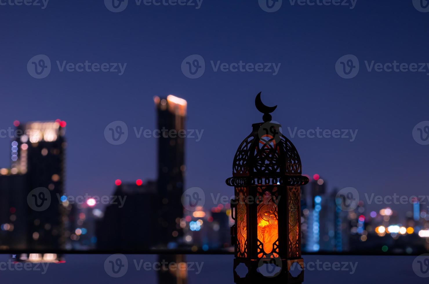 lantaarn dat hebben maan symbool Aan top met nacht stad achtergrond voor de moslim feest van de heilig maand van Ramadan kareem. foto