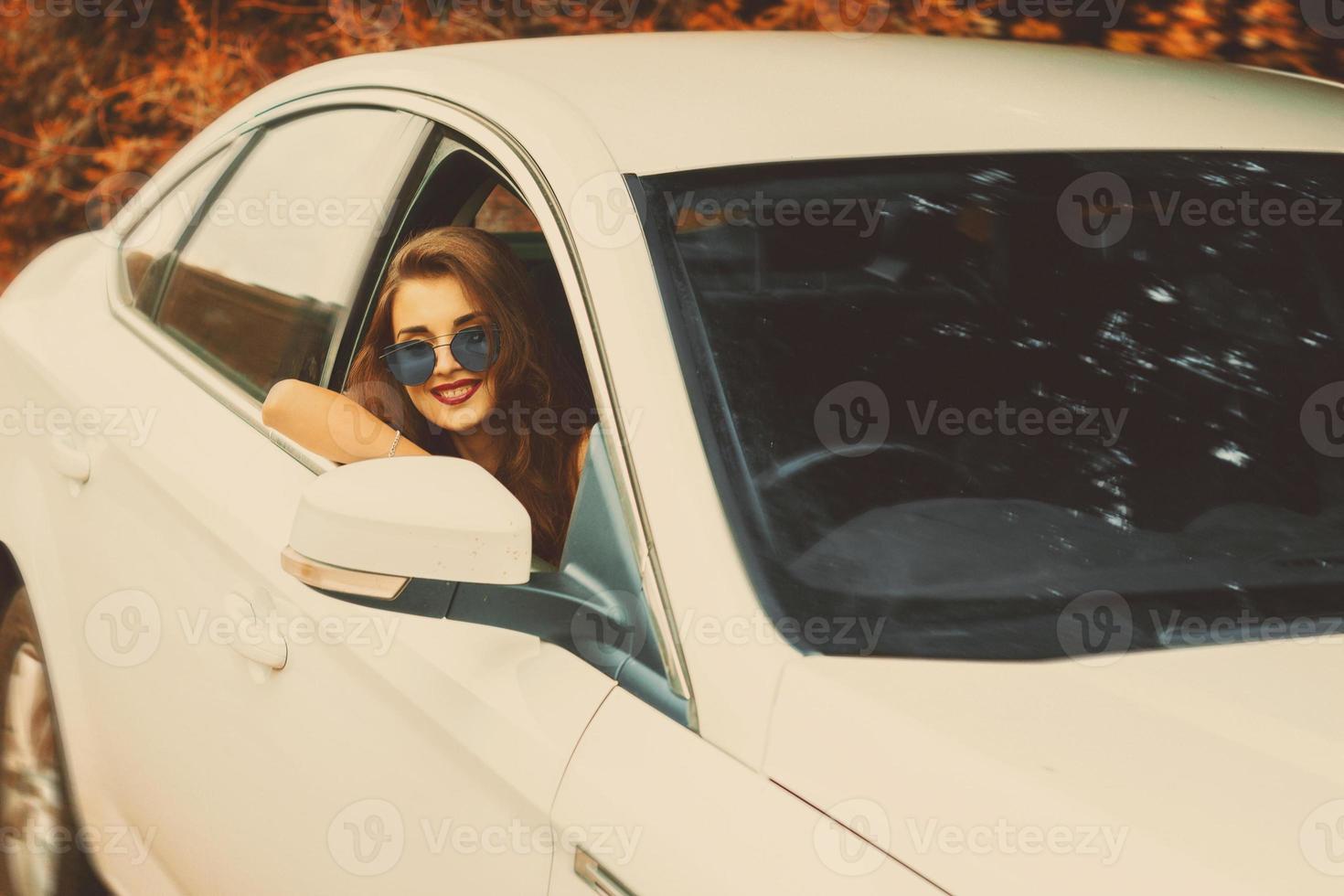 glimlachen meisje in zonnebril drogen een auto foto