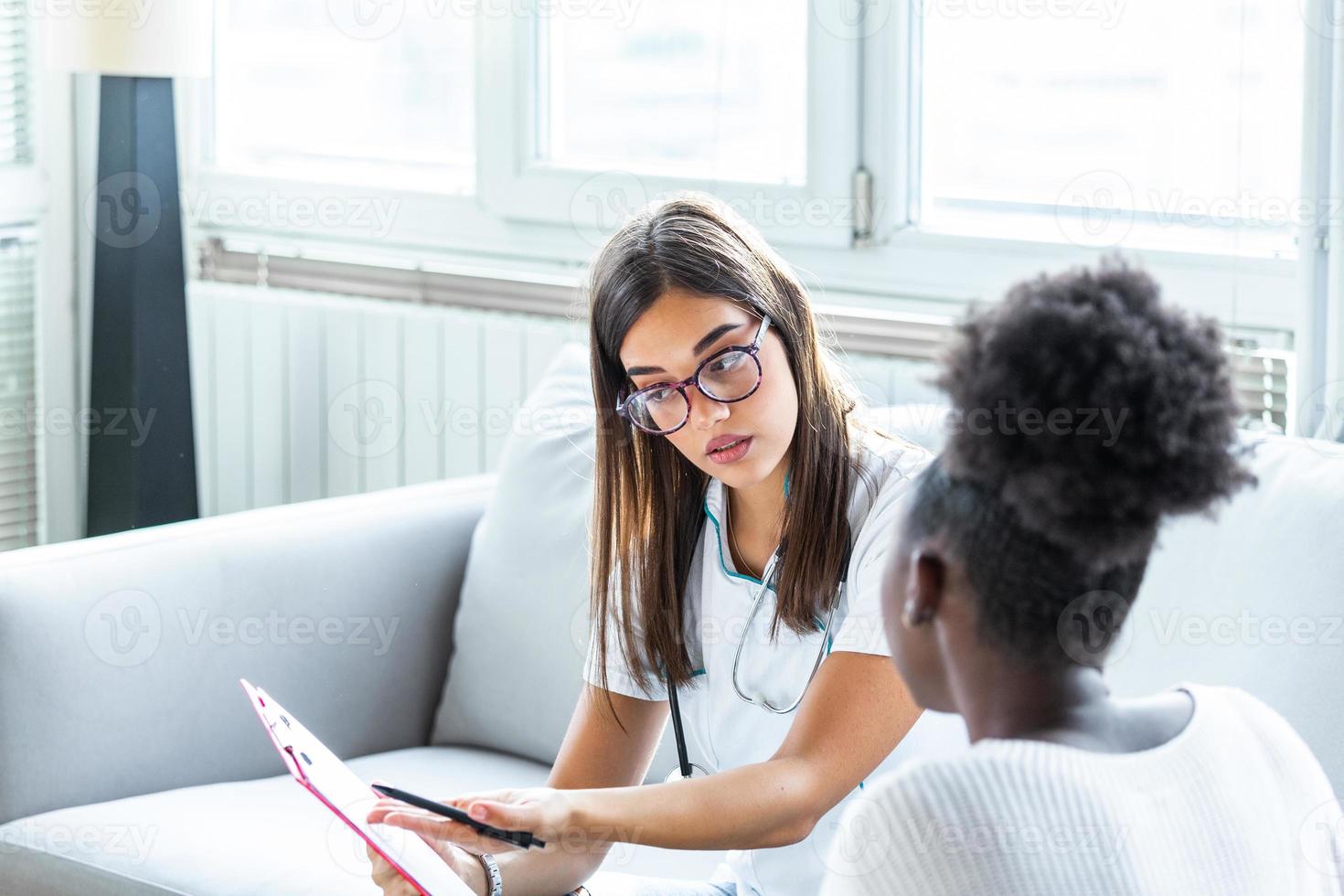 gezondheidszorg en geneeskunde concept - echt dokter met klembord en geduldig in ziekenhuis. visie van een jong dokter tonen resultaten Aan tablet naar geduldig foto