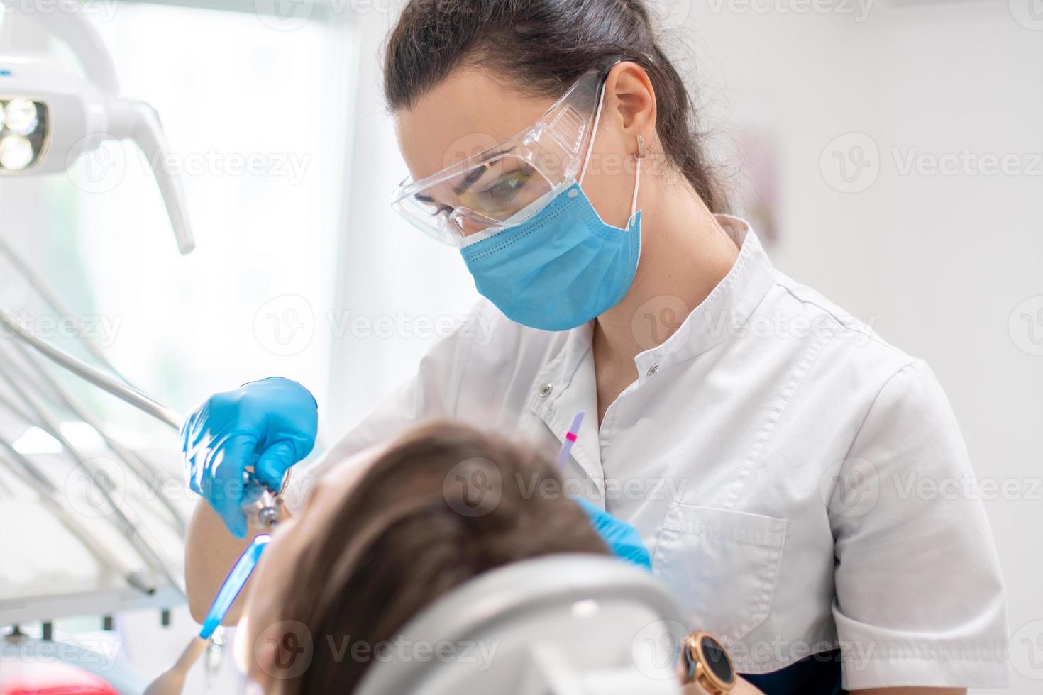 tandarts behandelt tanden naar een meisje in een kliniek foto