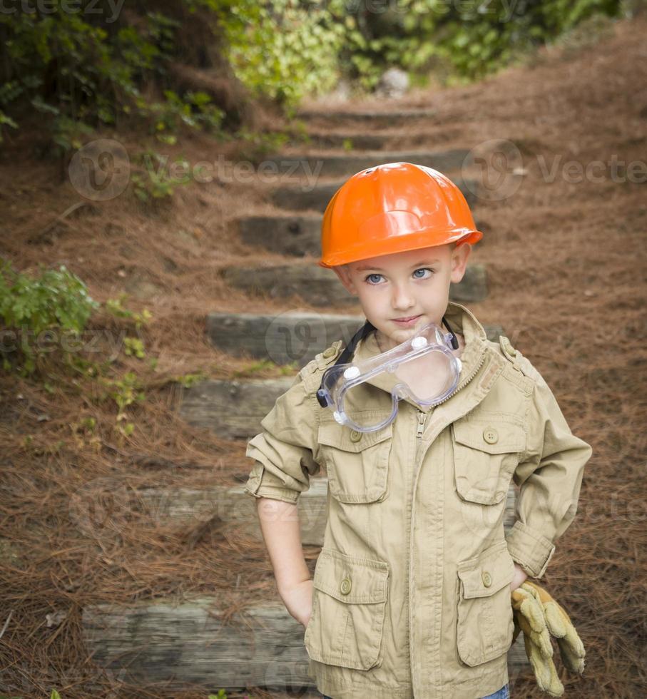 schattig kind jongen met grote handschoenen spelen klusjesman buiten foto